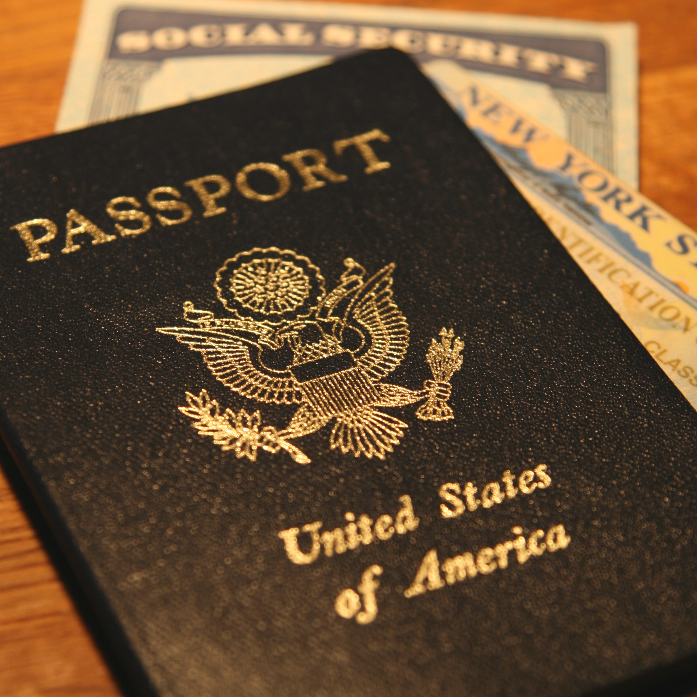 Up close image of a passport, drivers license, and social security card.
